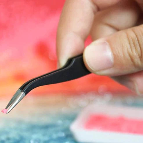 Hand holding pen applicator with drill bead custom diamond painting